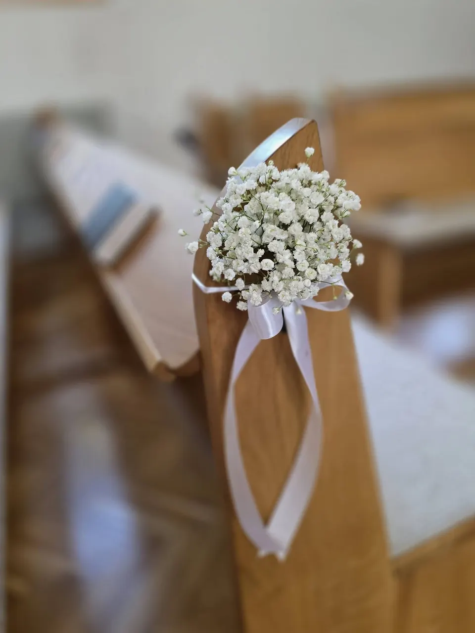 Decor cu gypsophila și panglică pe banca bisericii