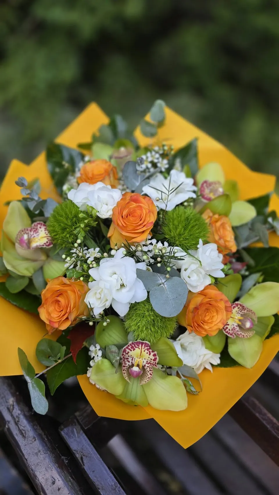 Buchet în nuanțe de portocaliu, alb și verde, în hârtie galbenă